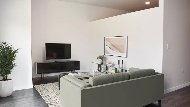 Modern living room with a green sofa, TV on a dark credenza, potted plant, and abstract wall art.