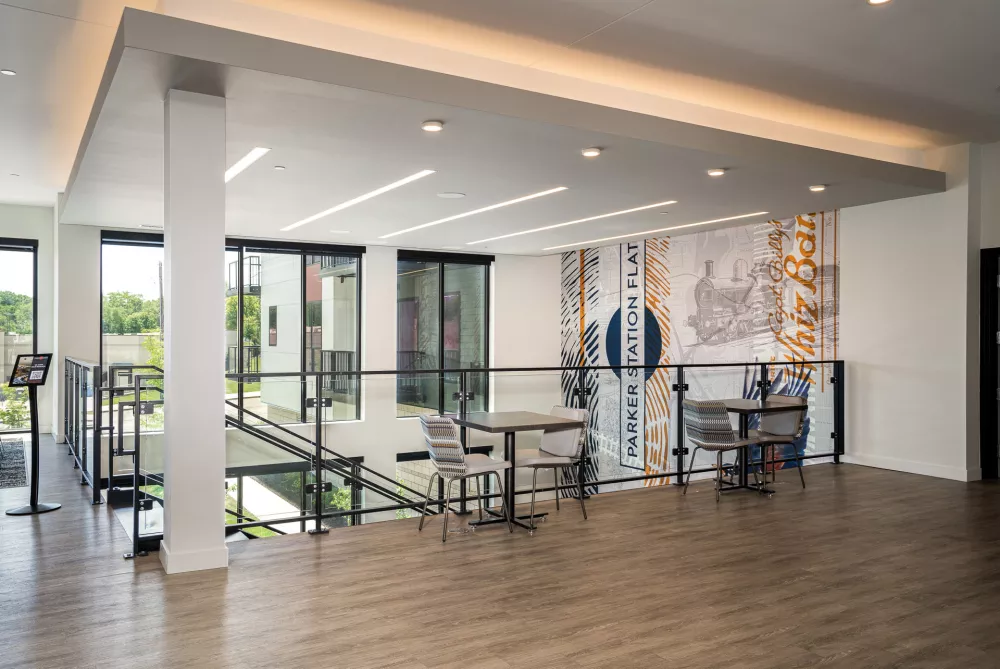 Bright, multi-level modern interior with two seating areas and a large, abstract mural on the back wall.